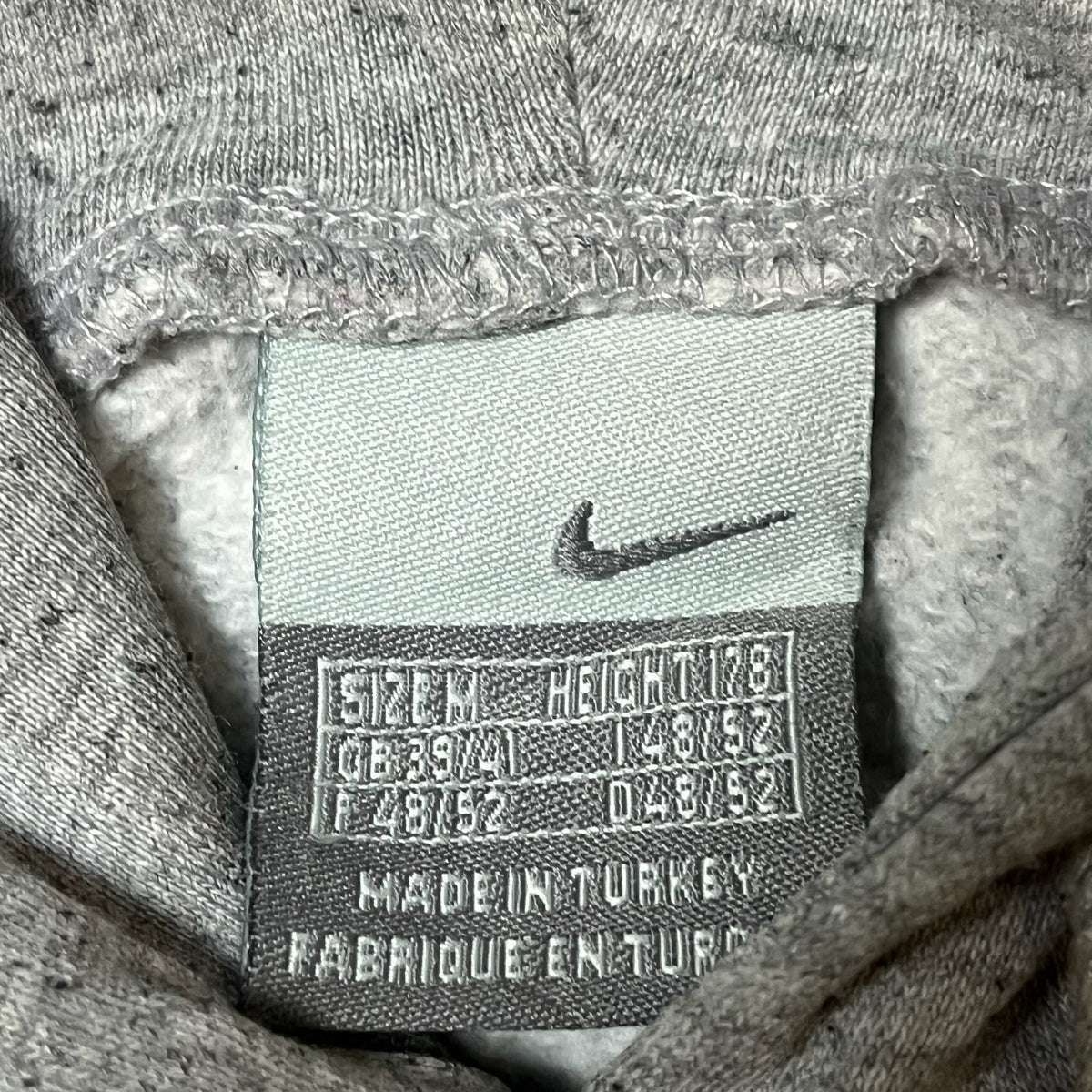 Étiquette de taille M du sweat à capuche Nike gris chiné