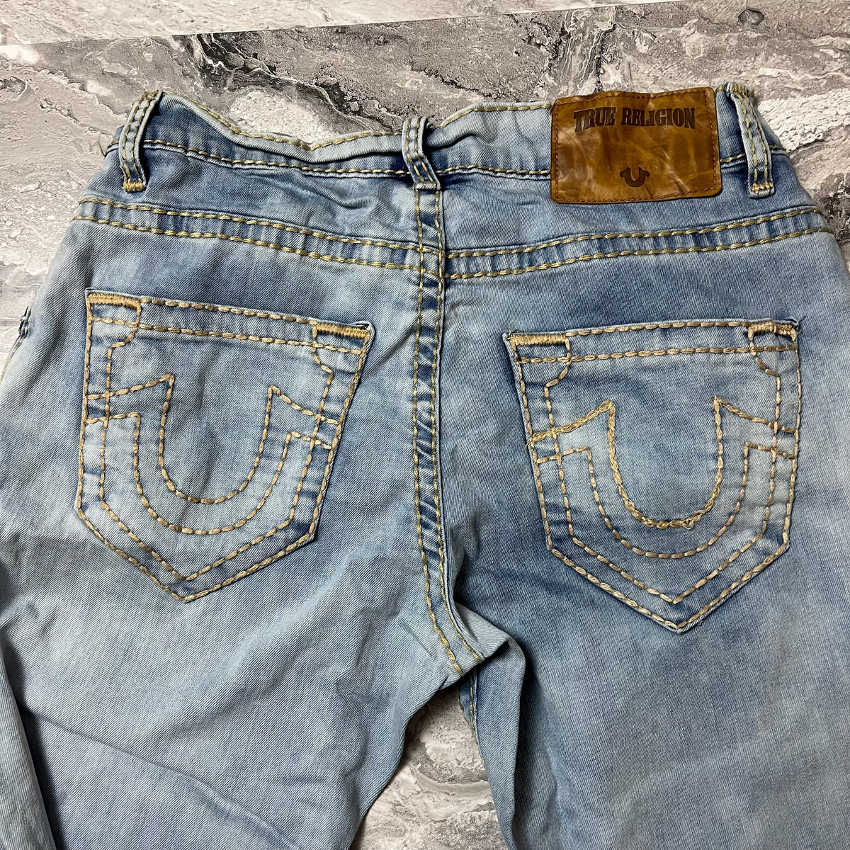 Détail dos jean True Religion avec étiquette cuir et poches brodées