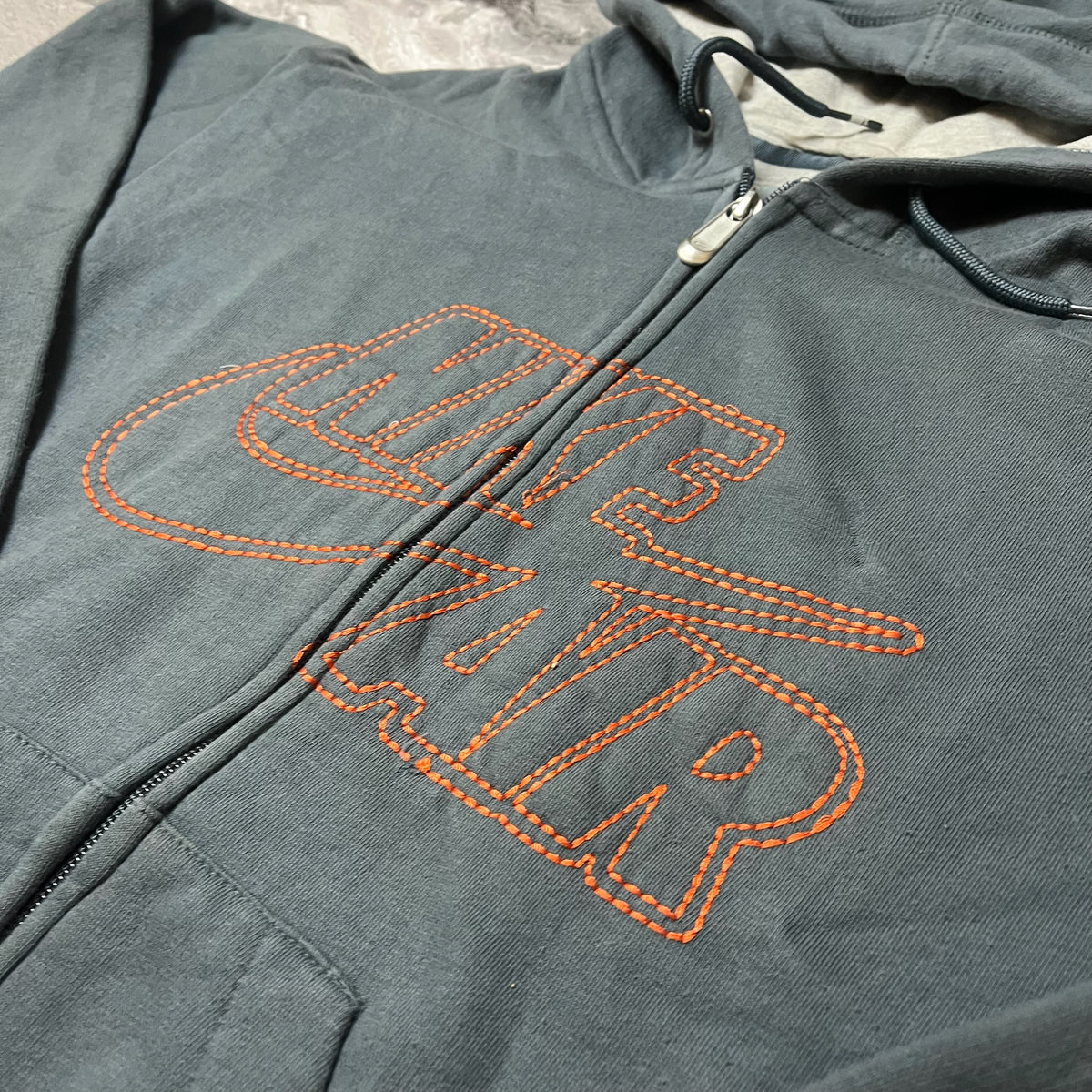 Détail du logo Nike Air orange sur sweat gris foncé