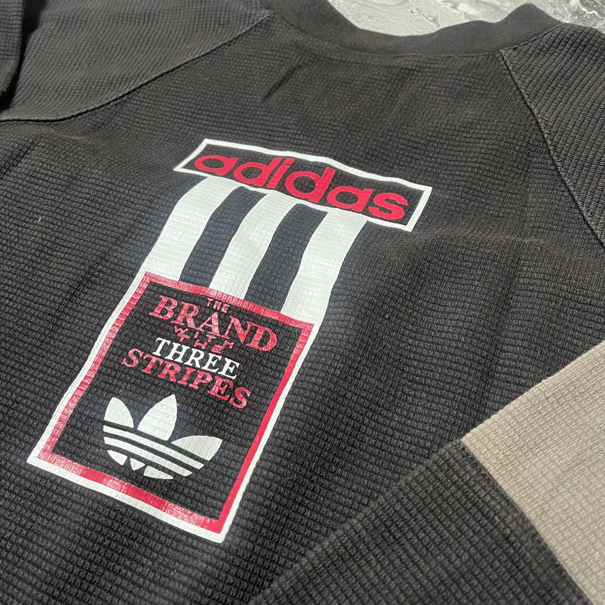 Détail du logo Adidas sur le dos du sweat