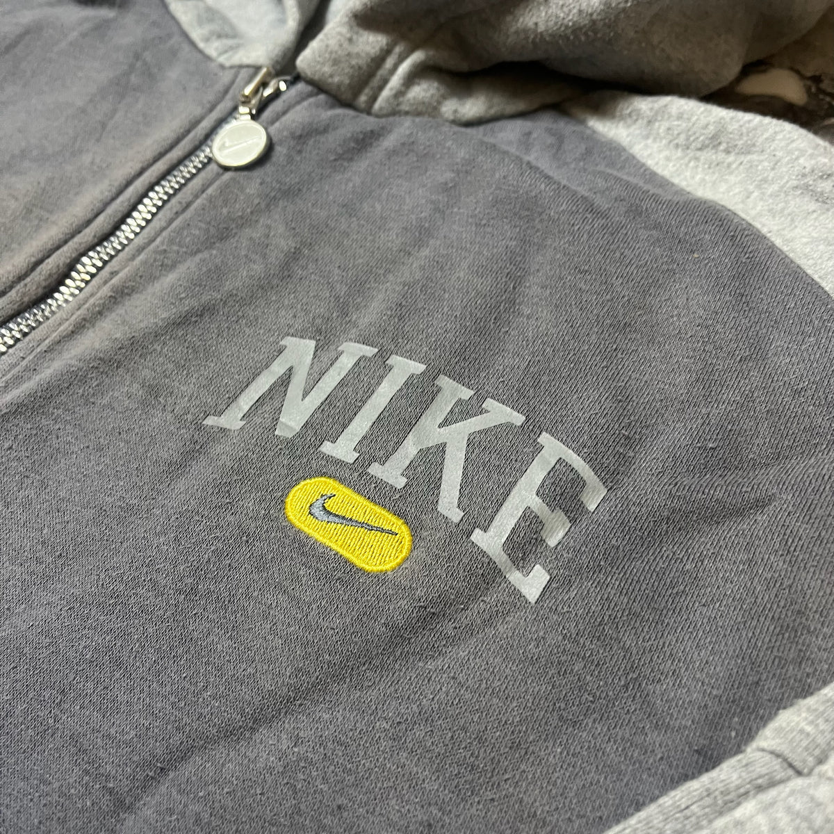 Détail du logo Nike brodé et imprimé sur le sweat gris