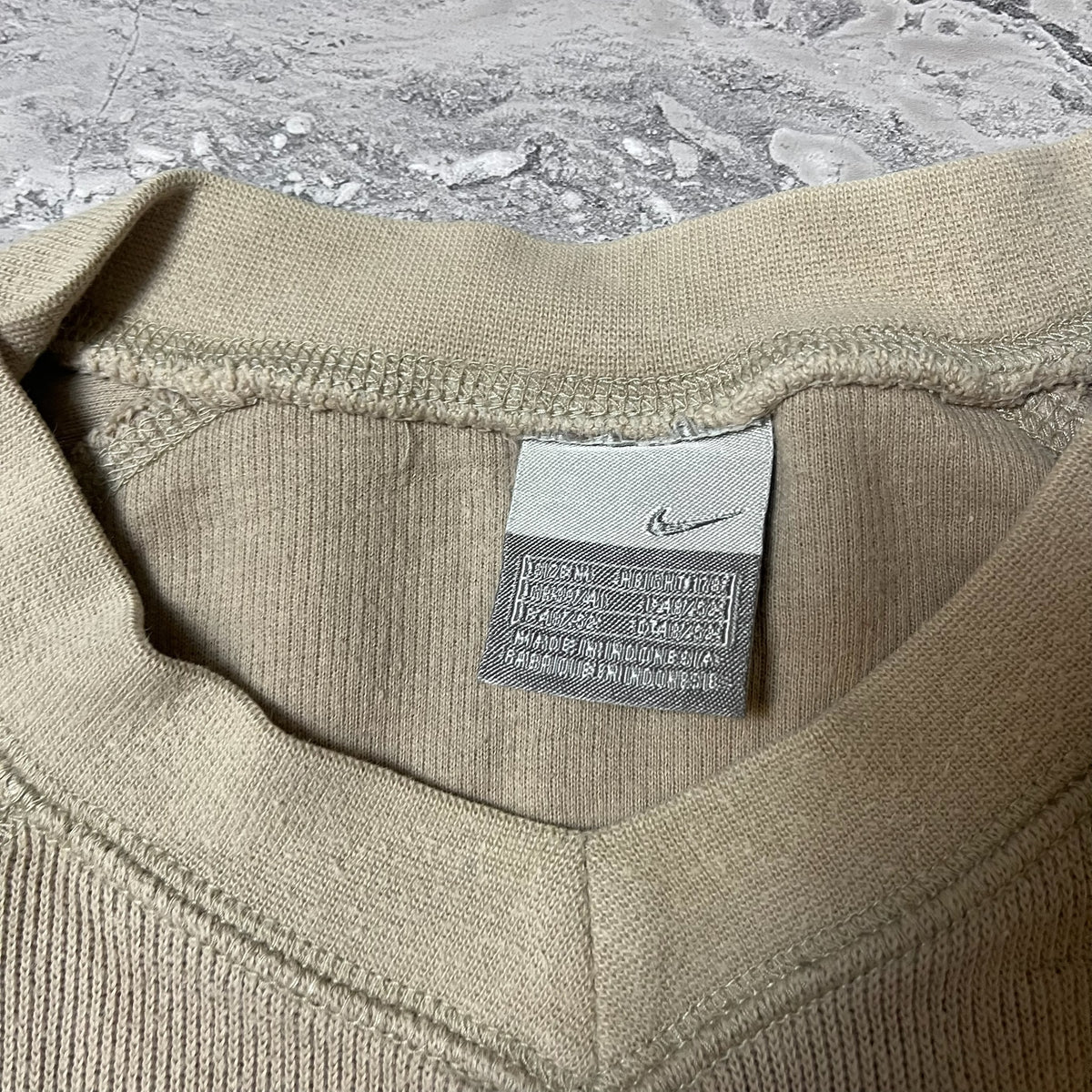Étiquette Nike avec taille M du sweat beige