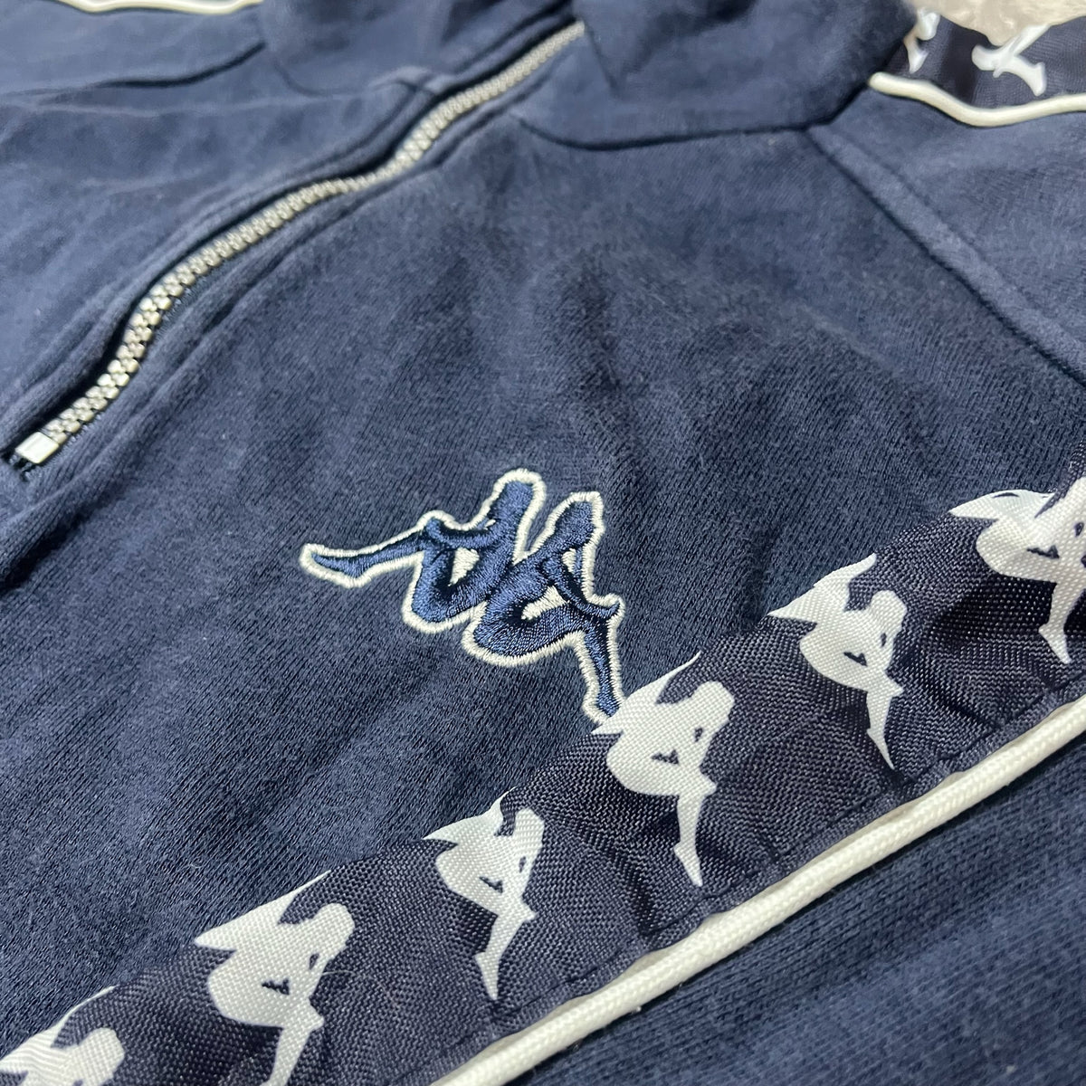 Détail du logo Kappa brodé sur la poitrine du sweat bleu marine
