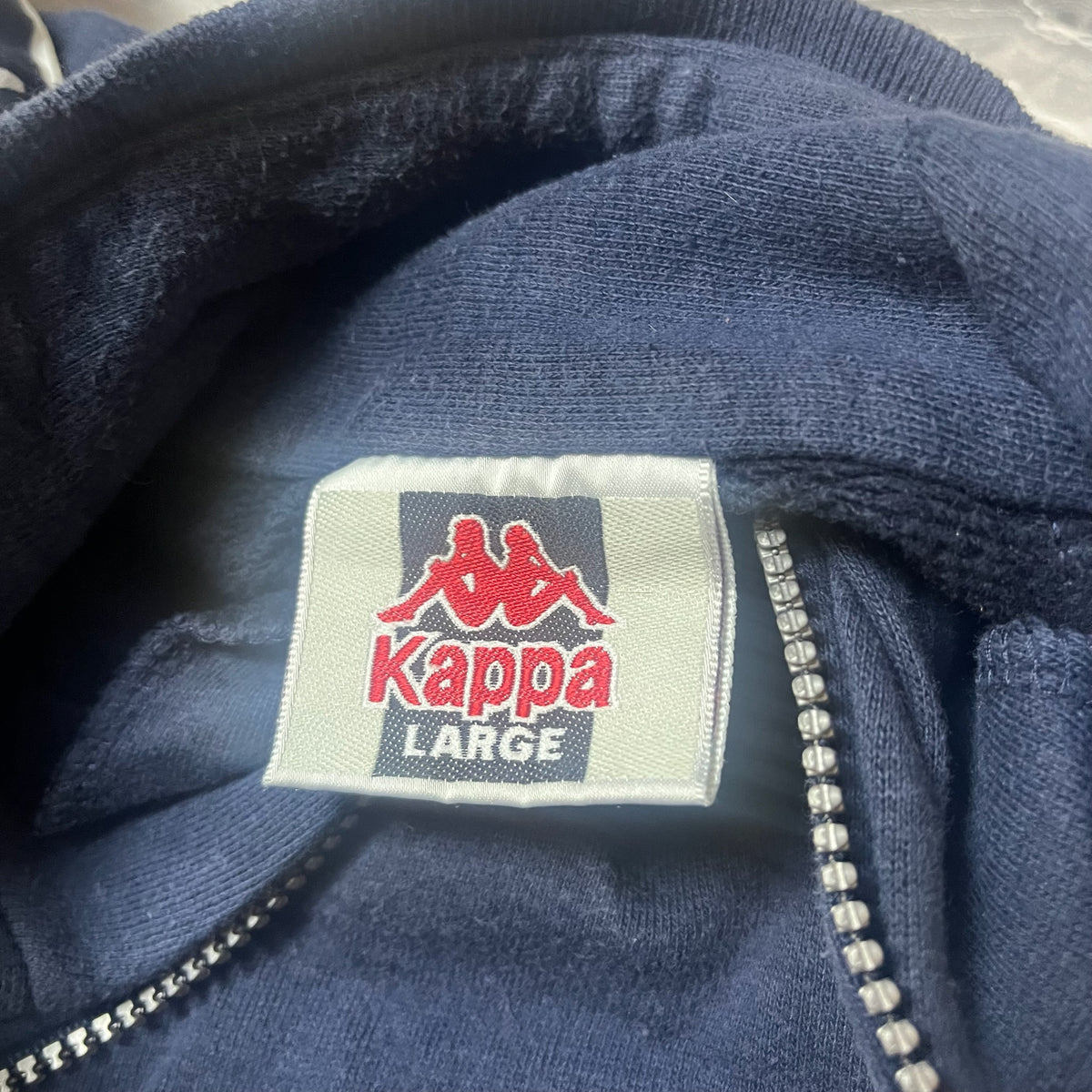 Étiquette Kappa indiquant la taille Large du sweat