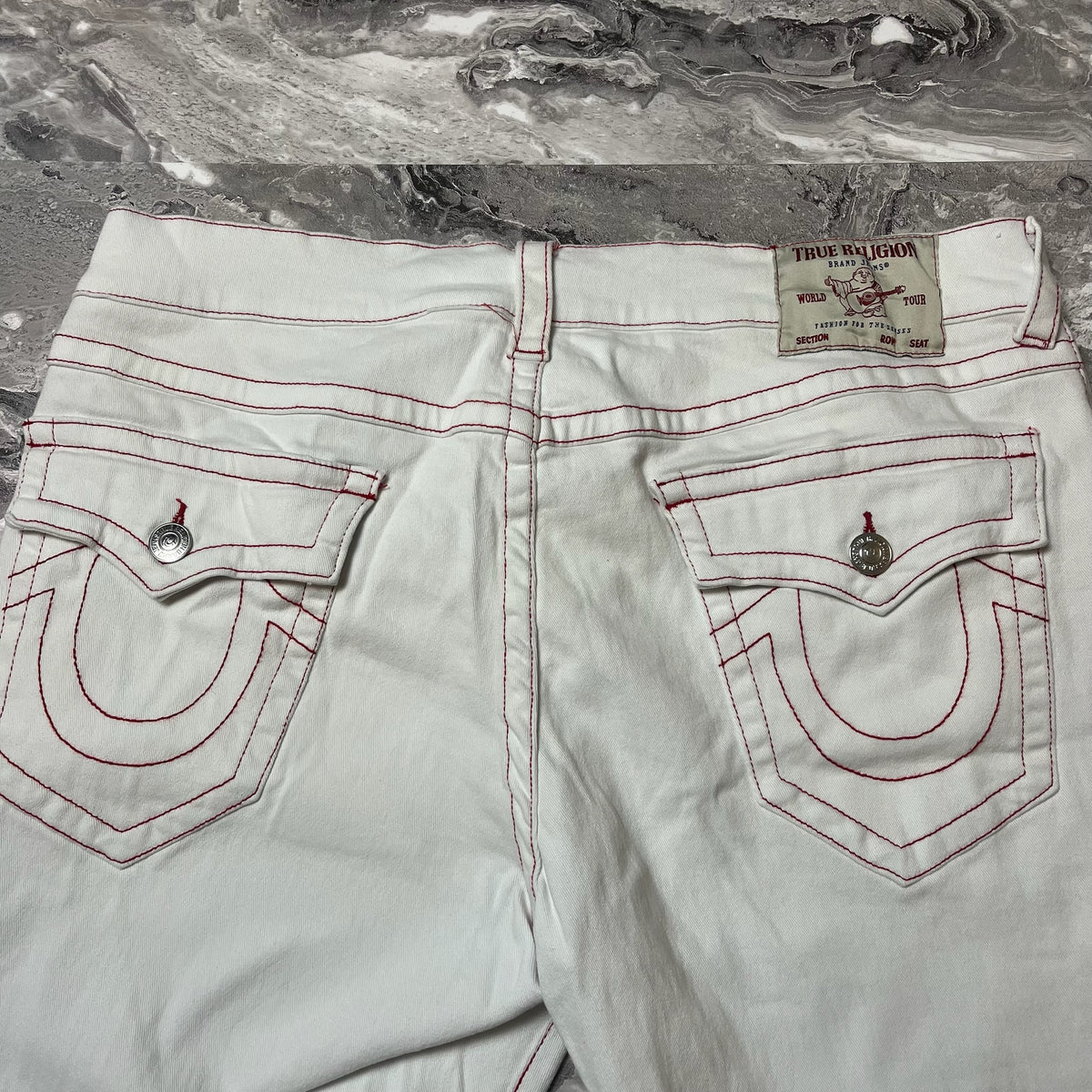 Dos jean True Religion blanc avec poches arrière rabat boutons et surpiqûres rouges