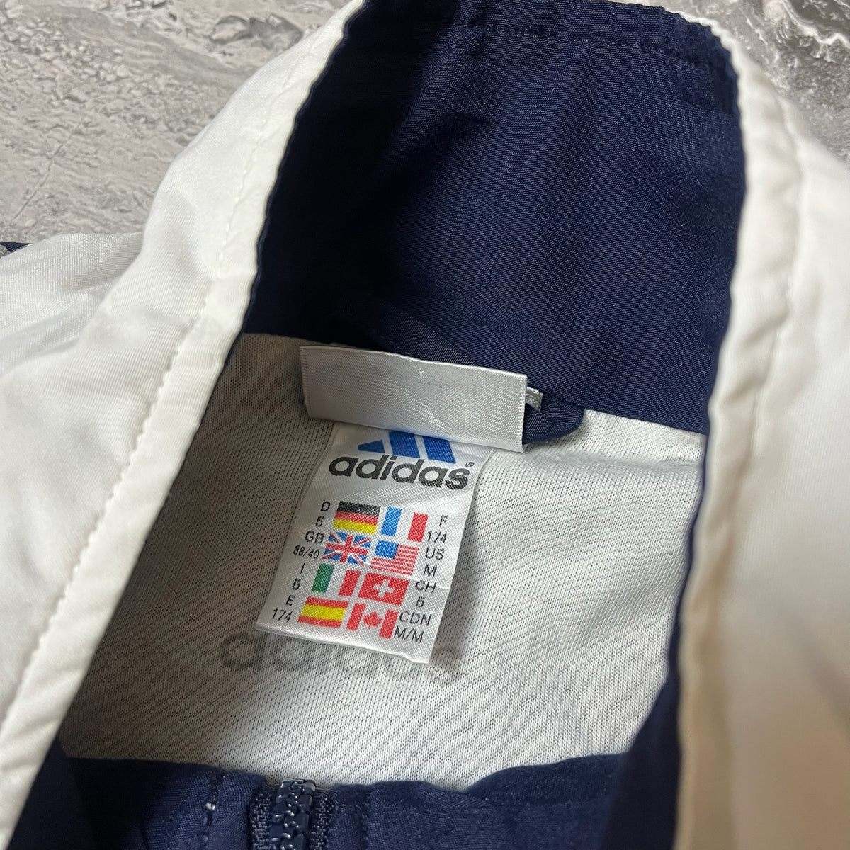 Étiquette Adidas taille M visible à l'intérieur du col
