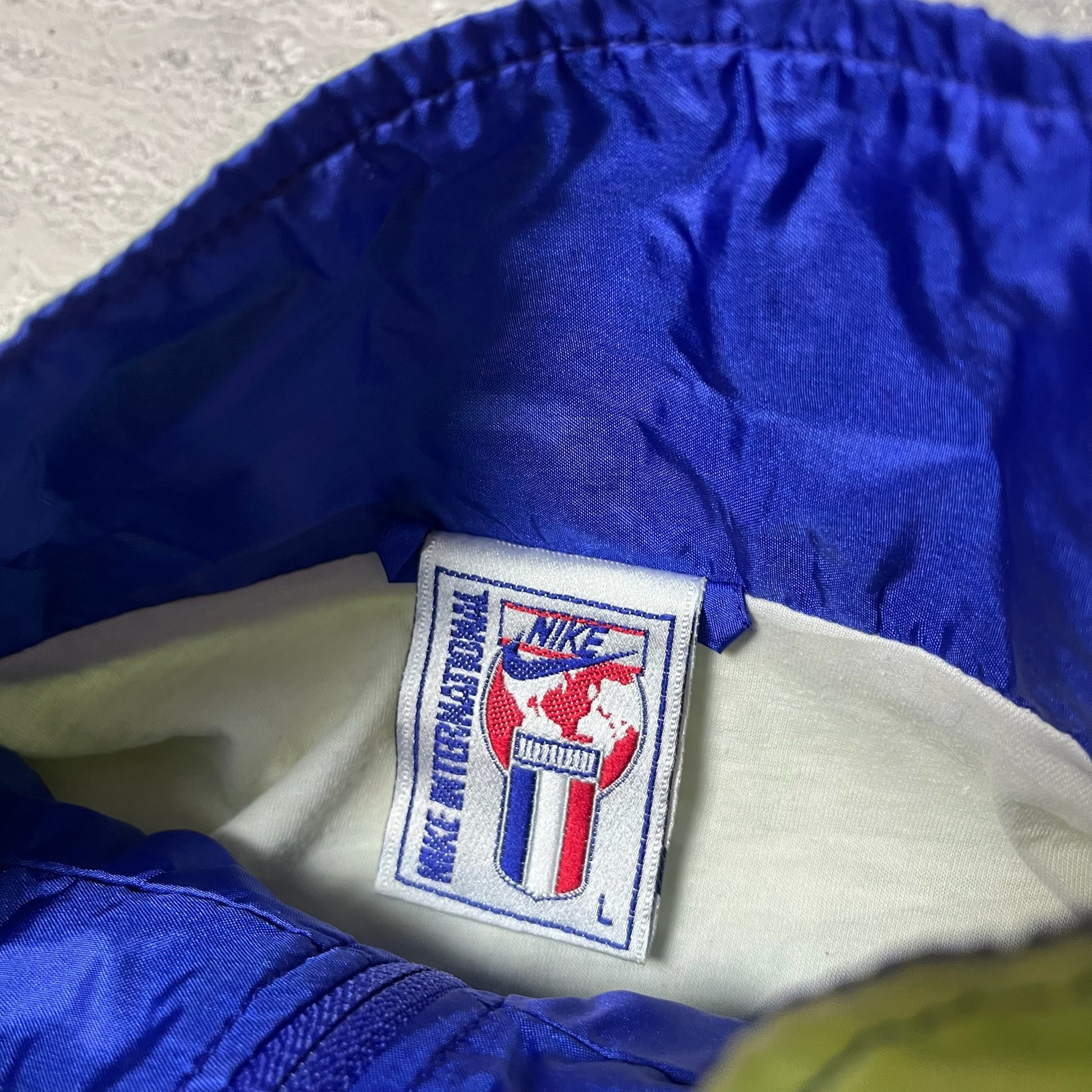 Étiquette Nike International taille L à l'intérieur de la veste
