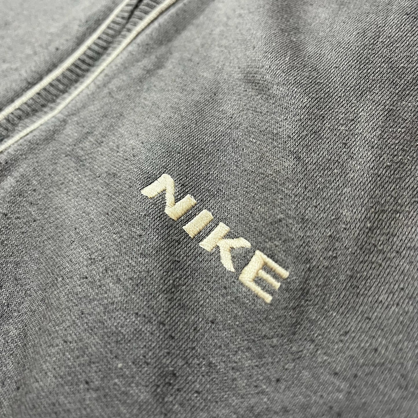 Détail du logo Nike brodé sur la poitrine du sweat gris foncé