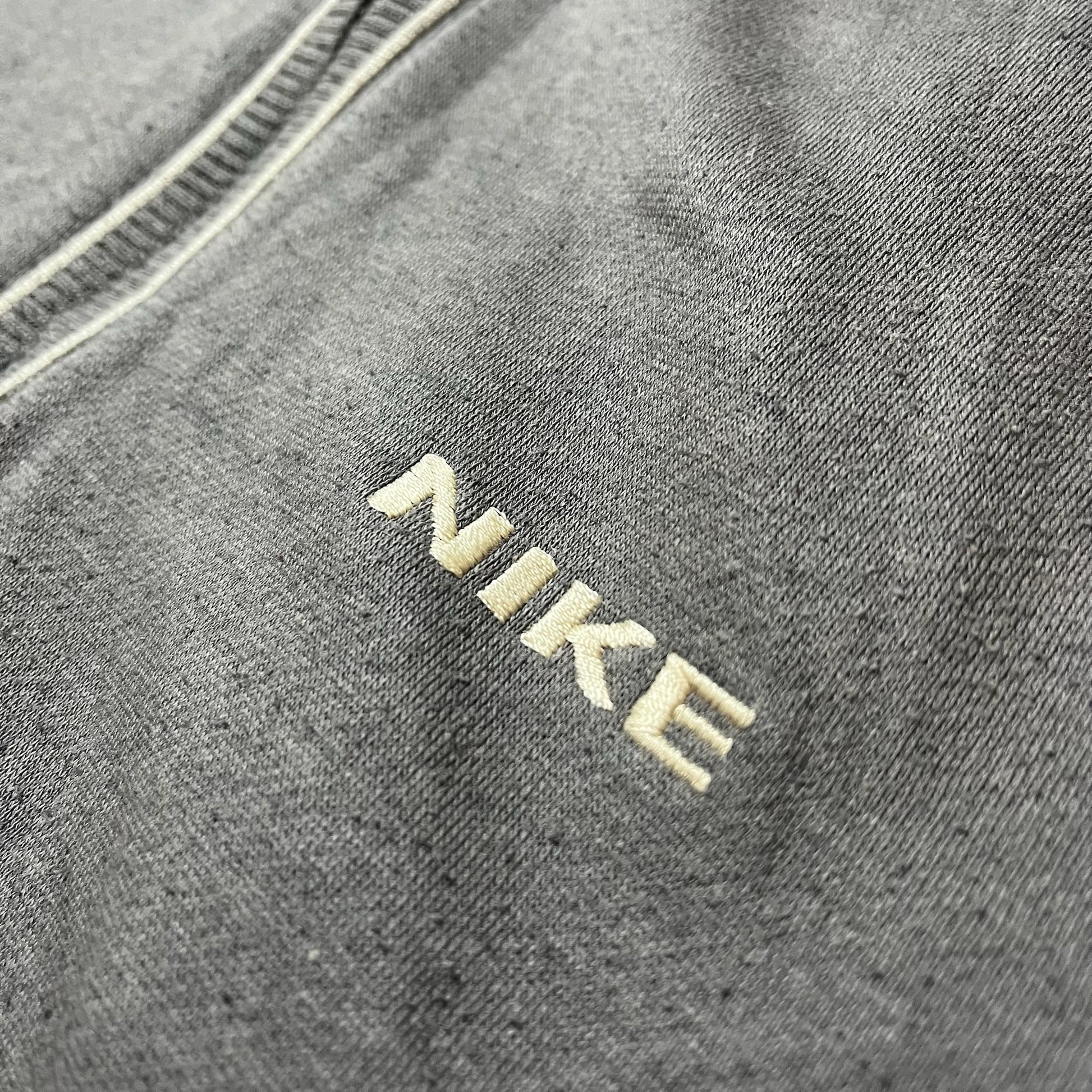 Détail du logo Nike brodé sur la poitrine du sweat gris foncé