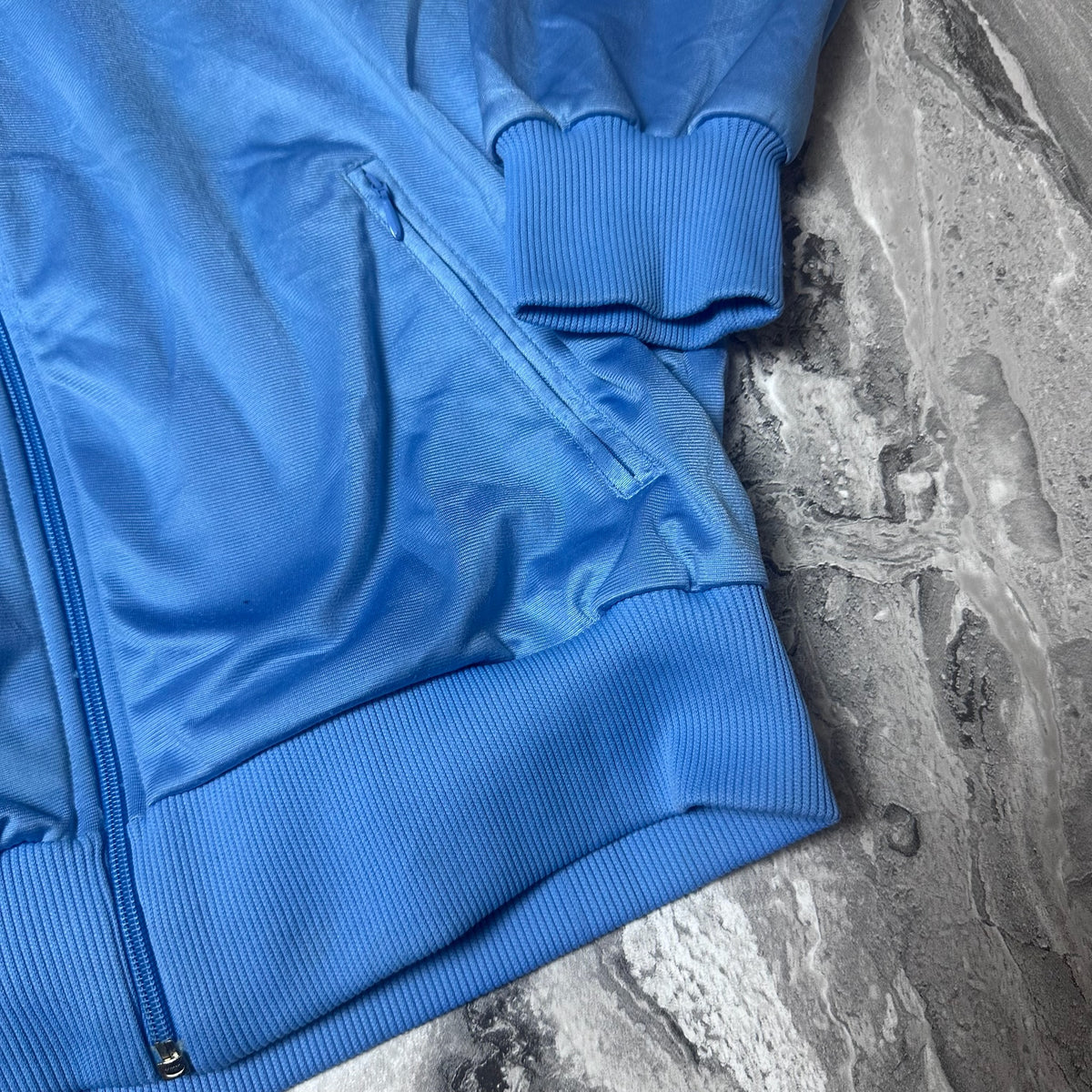 Détail logo Adidas brodé sur la veste bleue