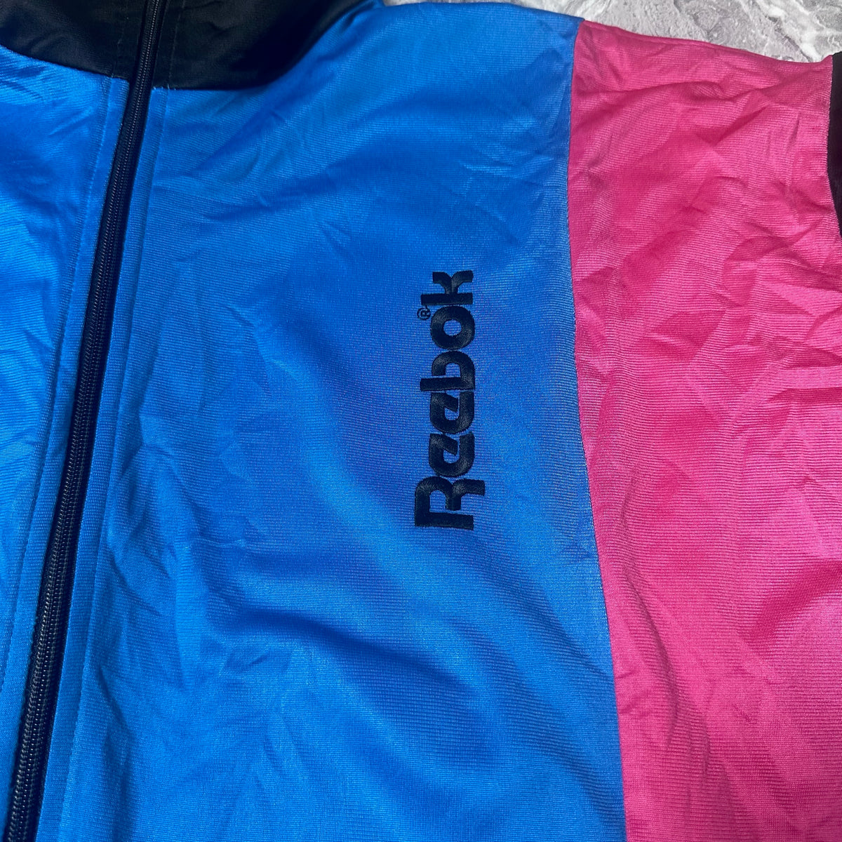 Détail logo Reebok brodé sur la poitrine de la veste
