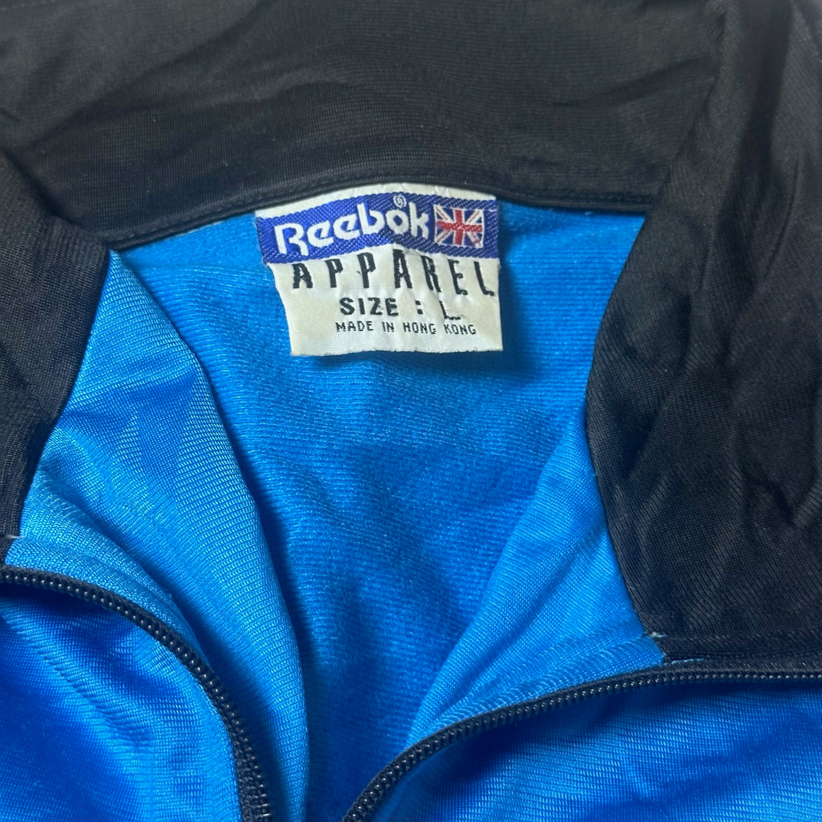 Étiquette Reebok taille L sur la veste multicolore