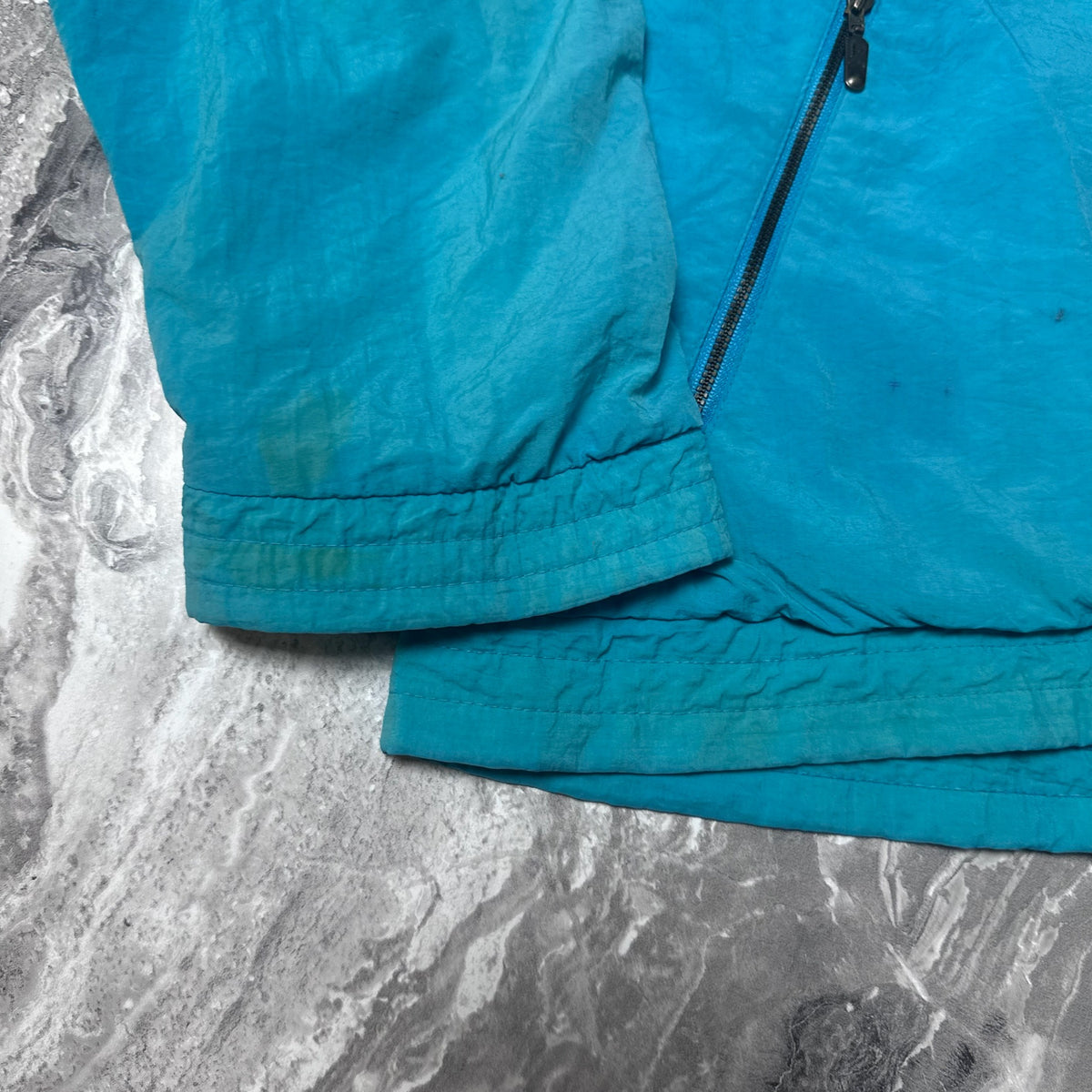 Manche de la veste Puma avec traces de salissures visibles