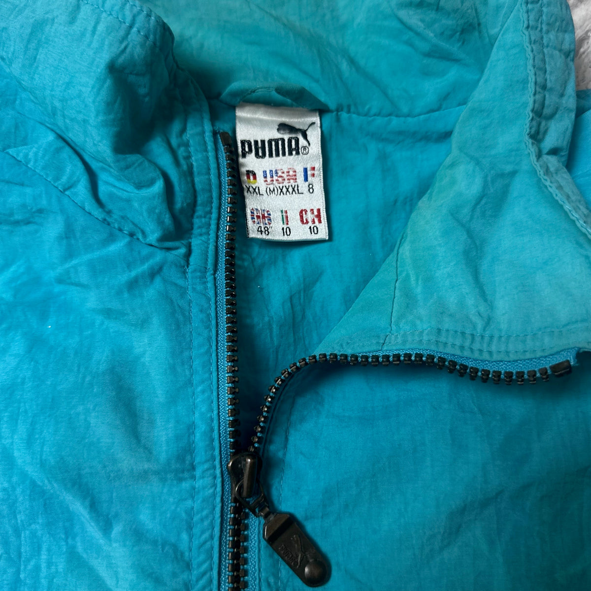 Étiquette de taille Puma XXL sur la veste bleue
