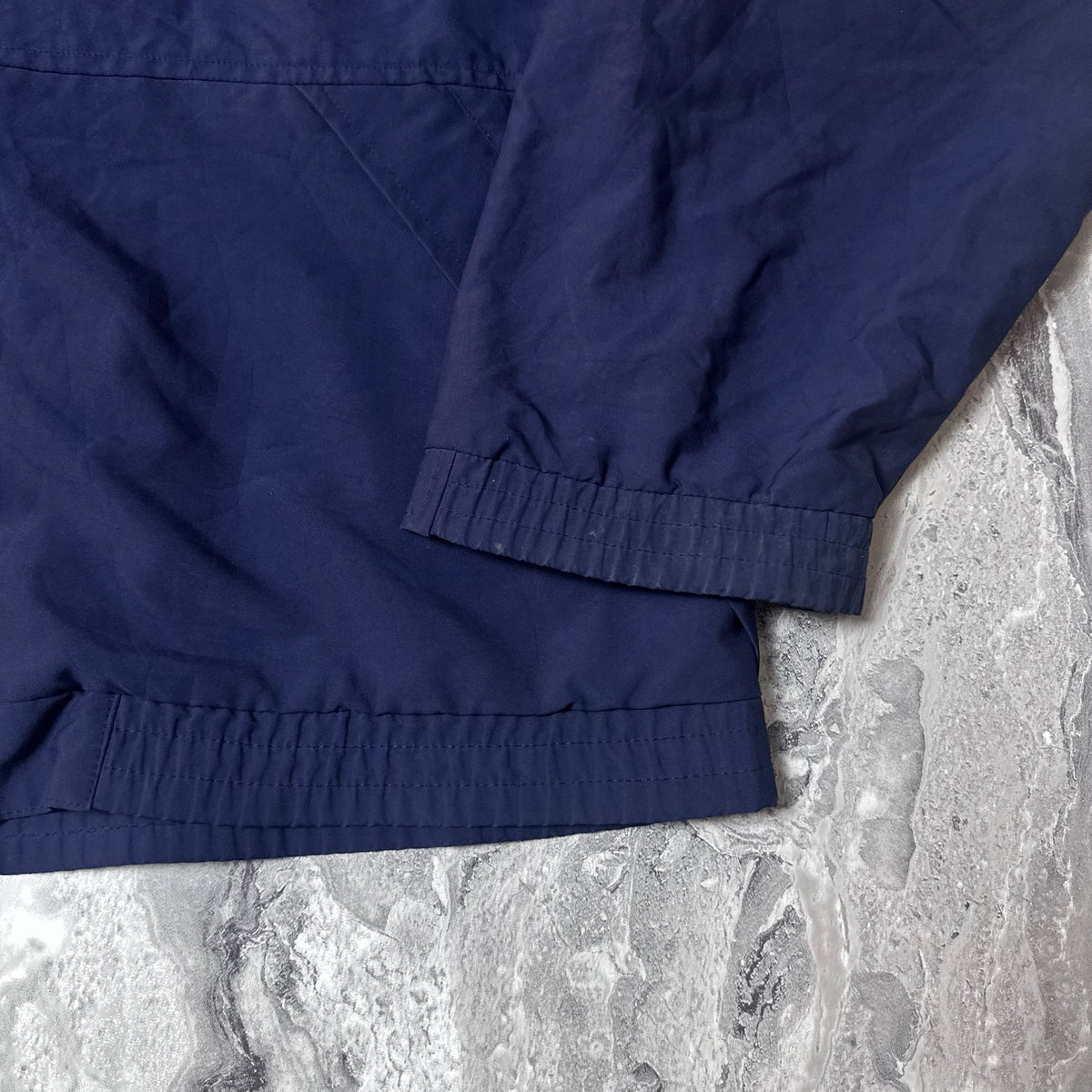 Poignet et bas élastiques de la veste Adidas golf bleu marine