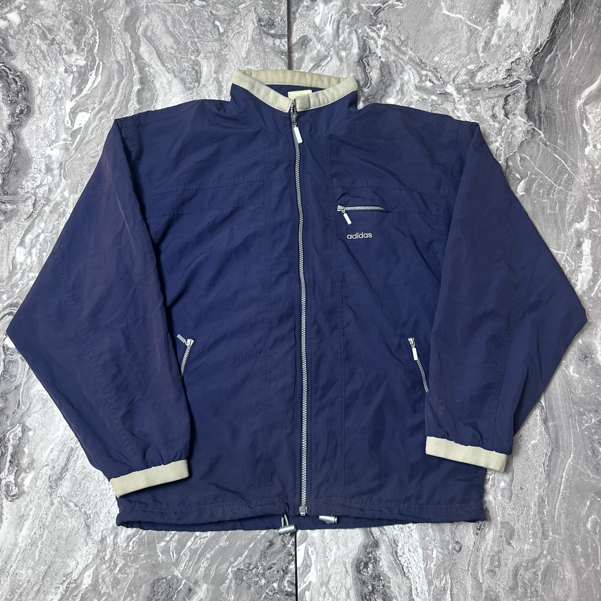 Veste Adidas bleu marine avec fermeture zippée vue de face