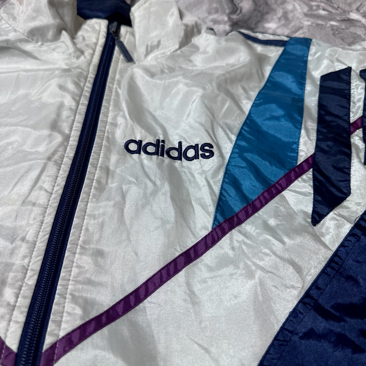 Détail du logo Adidas brodé sur la poitrine de la veste vintage