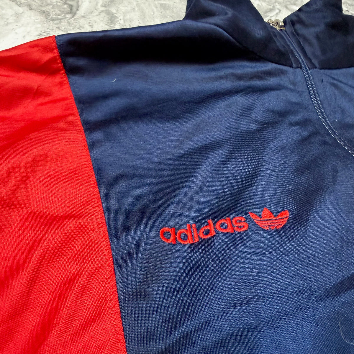 Détail logo brodé Adidas rouge sur la poitrine