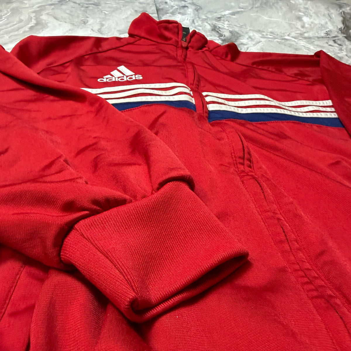 Étiquette Adidas taille S à l’intérieur du sweat rouge