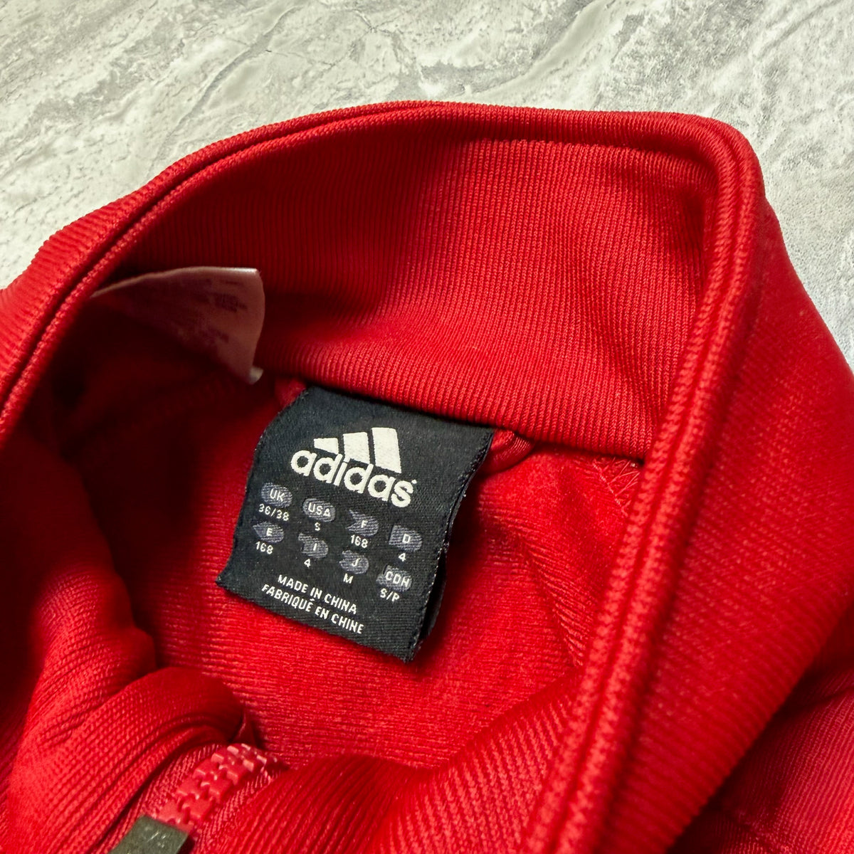 Dos du sweat Adidas rouge avec logo imprimé en haut