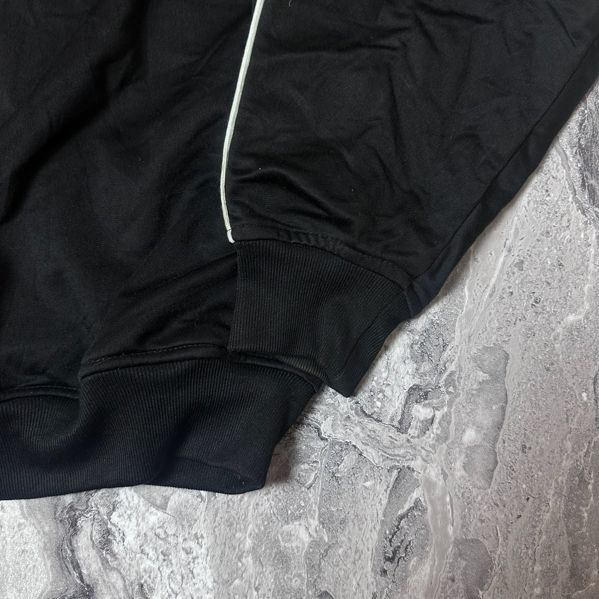 Poignets et base élastiqués de la veste Kappa noire