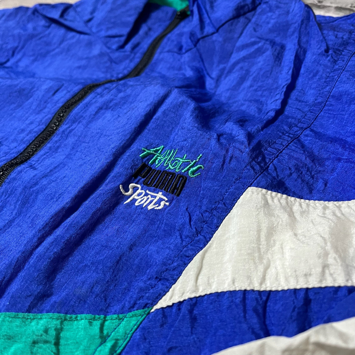Détail du logo brodé 'Athletic Puma Sports' sur la poitrine de la veste
