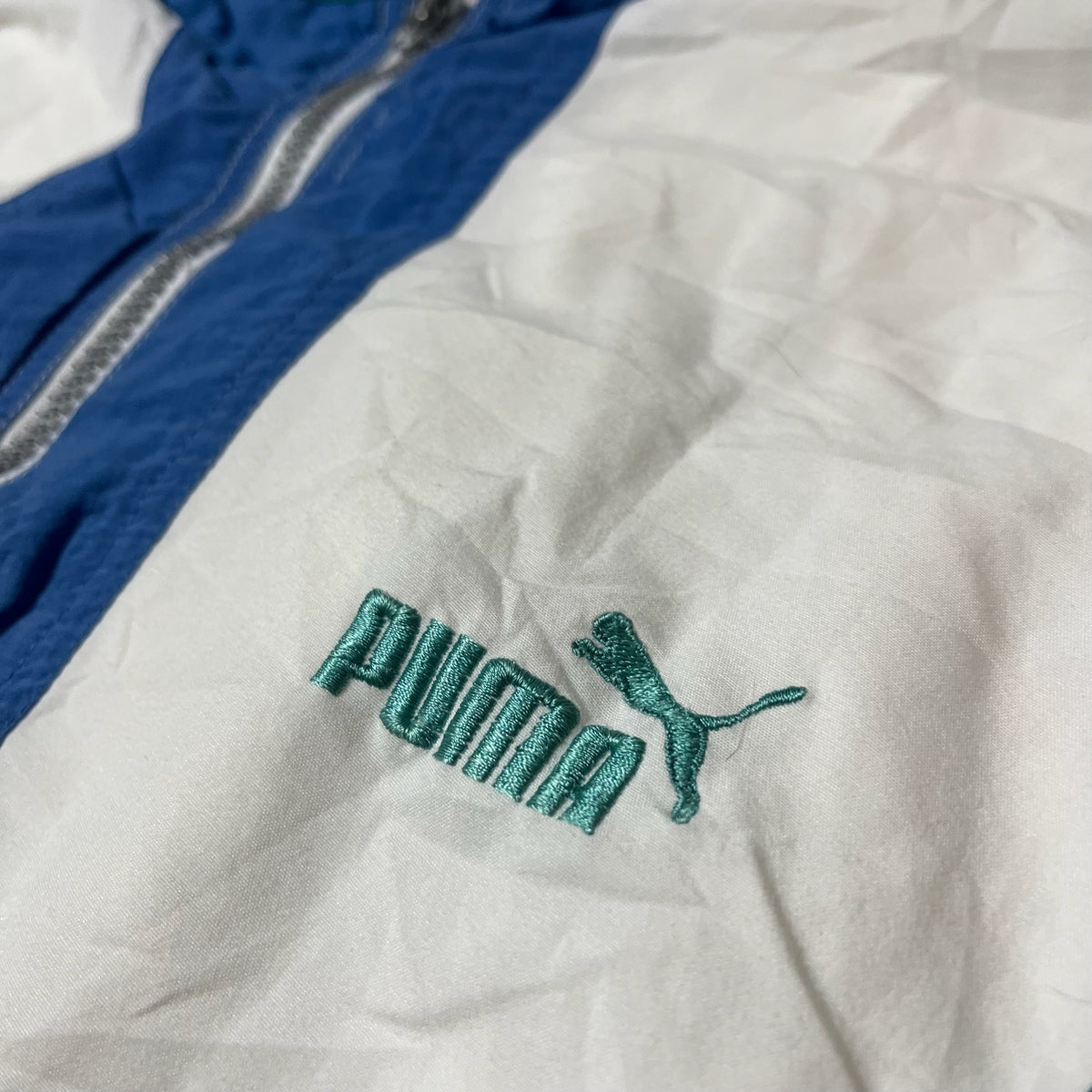 Détail du logo brodé Puma vert sur la poitrine