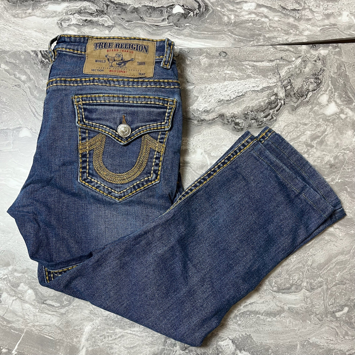 Jean True Religion denim bleu plié avec poche arrière visible