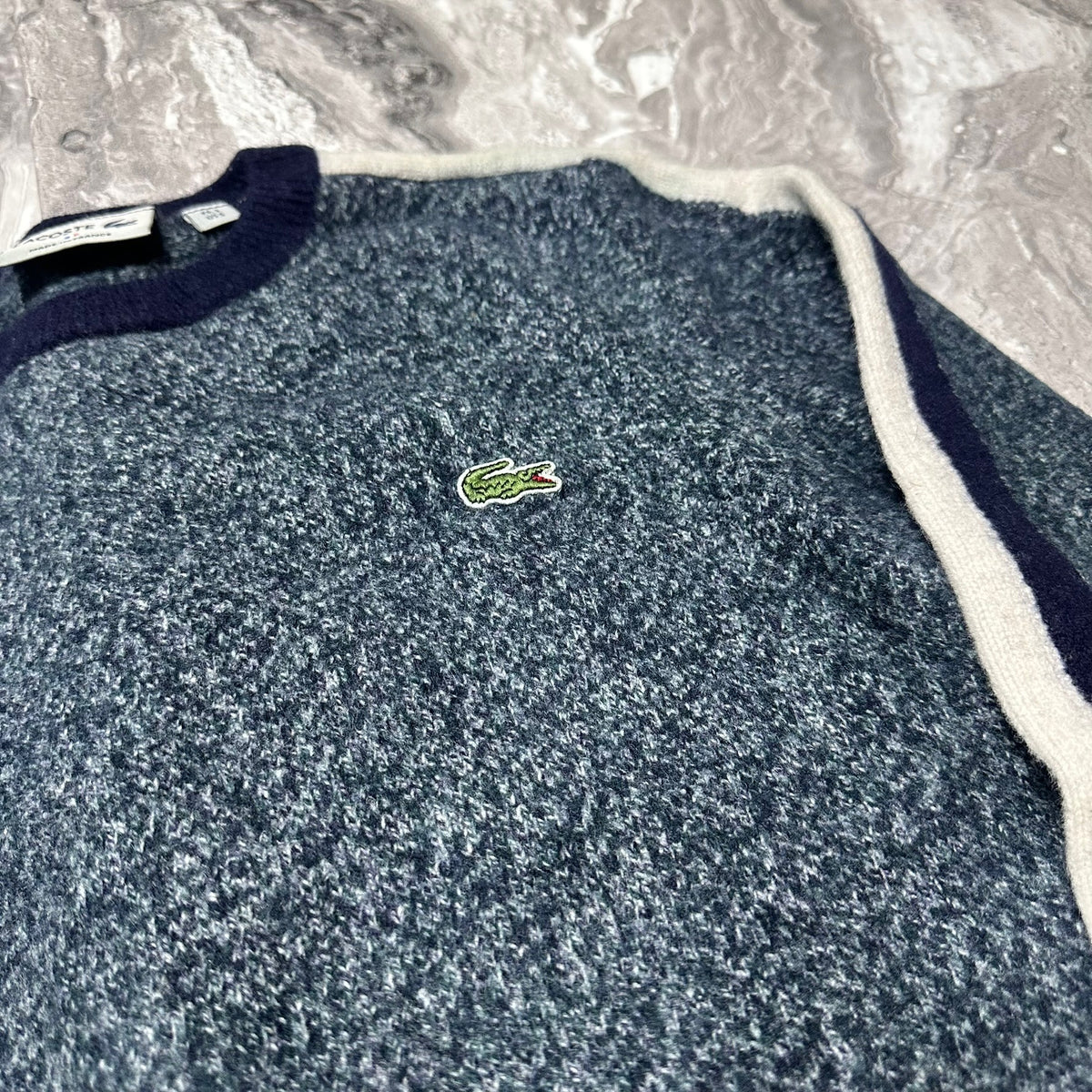 Détail du logo crocodile brodé sur le pull Lacoste bleu chiné