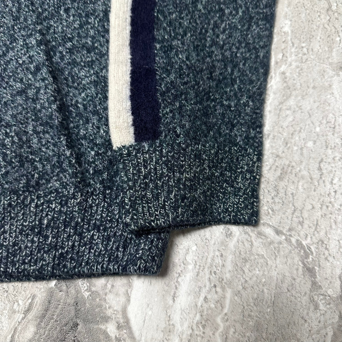 Étiquette de taille et de marque Lacoste sur le pull bleu chiné