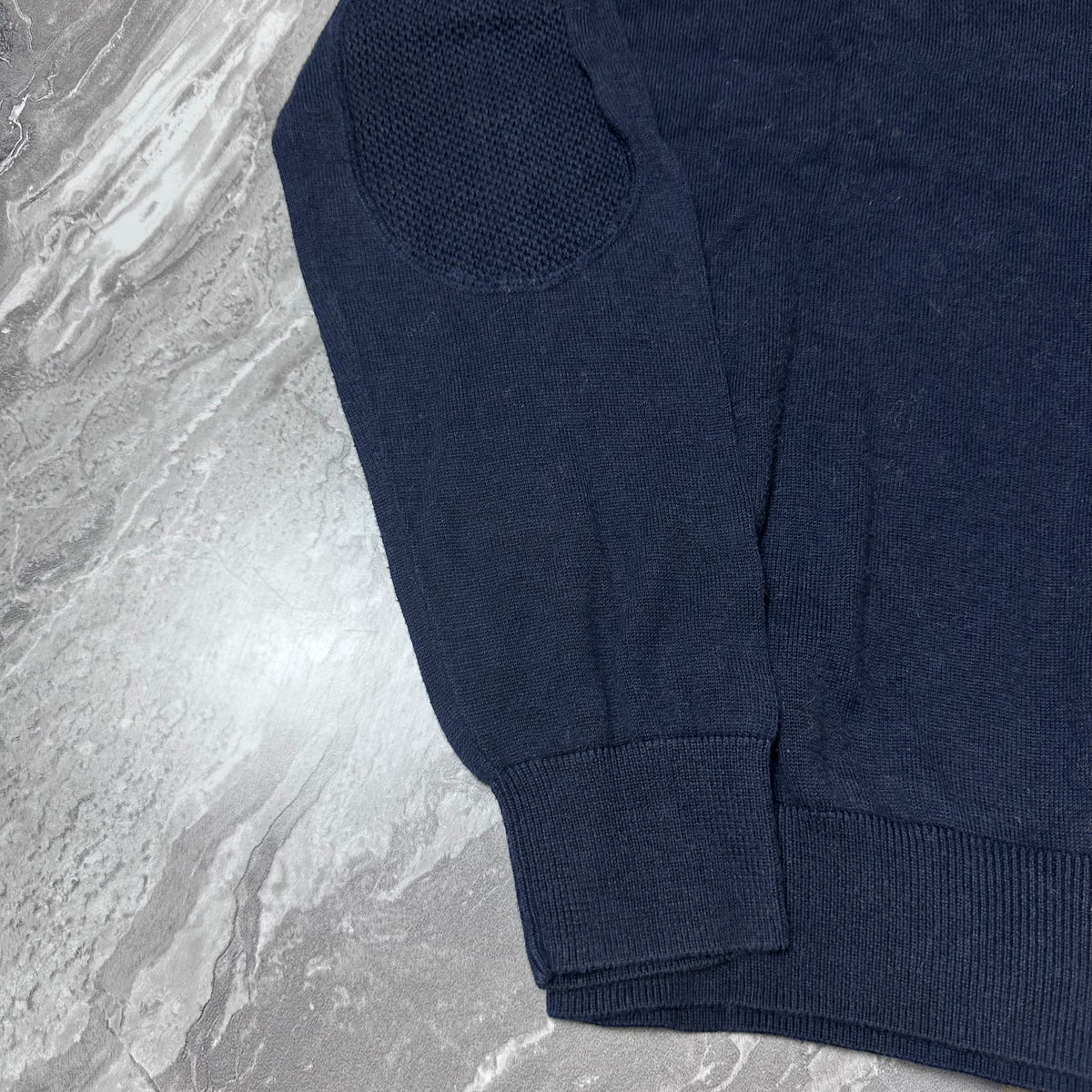 Détail des coudières en maille du pull Lacoste bleu marine