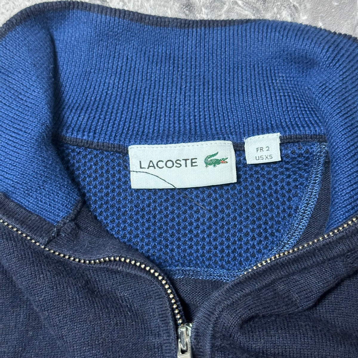 Étiquette de marque Lacoste et taille FR 2 US XS du pull