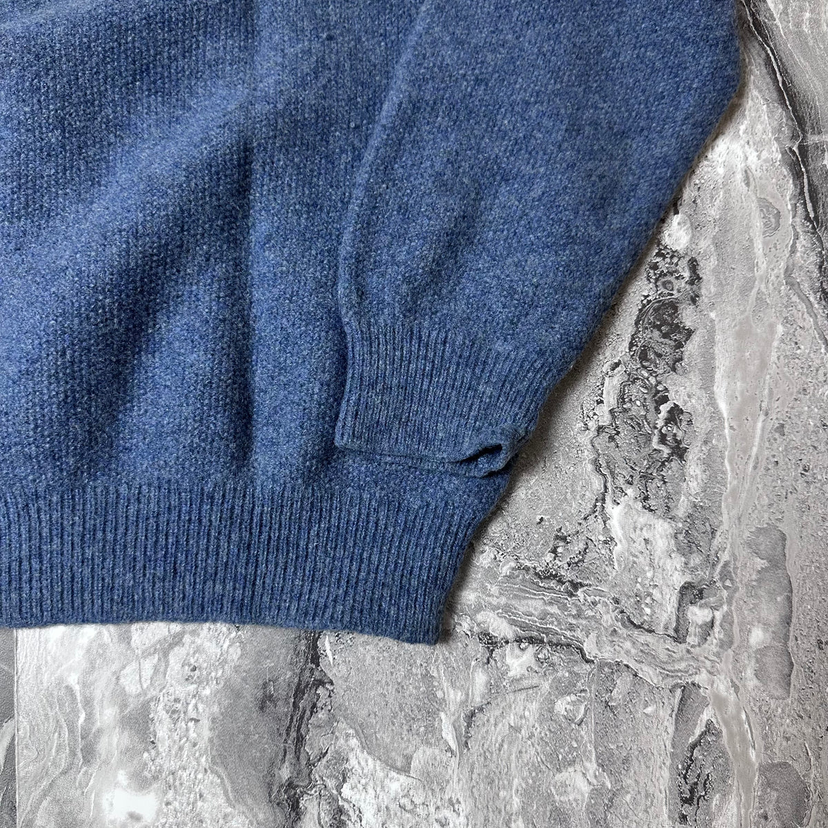Détail du bord côte au poignet du pull Lacoste bleu