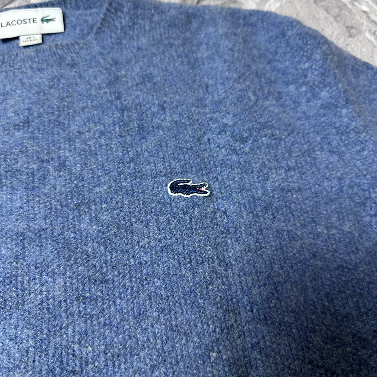 Détail du logo crocodile brodé sur le pull Lacoste bleu